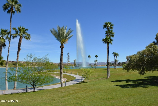 surrounding community featuring a water view and a lawn