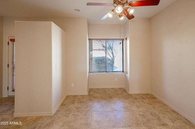 unfurnished room with a ceiling fan, baseboards, and light tile patterned floors