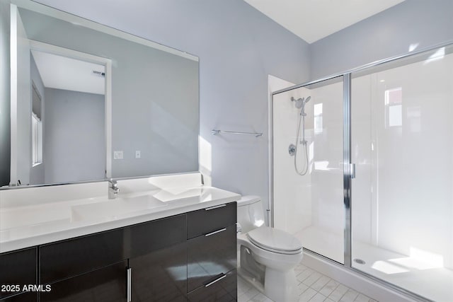 bathroom featuring a shower with door, tile patterned floors, vanity, and toilet