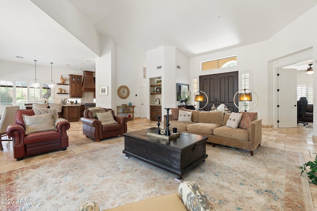 7734 E Monica Dr, Scottsdale, AZ 85255 - living area featuring stone tile floors, a towering ceiling, and a ceiling fan