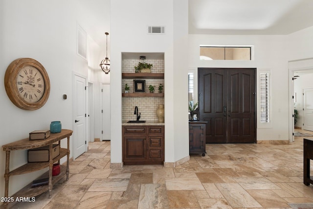 7734 E Monica Dr, Scottsdale, AZ 85255 - entrance foyer with a towering ceiling, stone tile floors, and baseboards