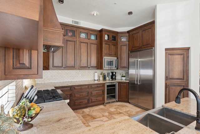 7734 E Monica Dr, Scottsdale, AZ 85255 - kitchen with built in appliances, a sink, wine cooler, decorative backsplash, and light stone finish floors