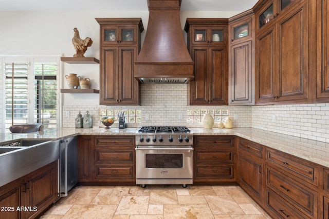 7734 E Monica Dr, Scottsdale, AZ 85255 - kitchen with stainless steel range, custom range hood, open shelves, stone tile flooring, and backsplash