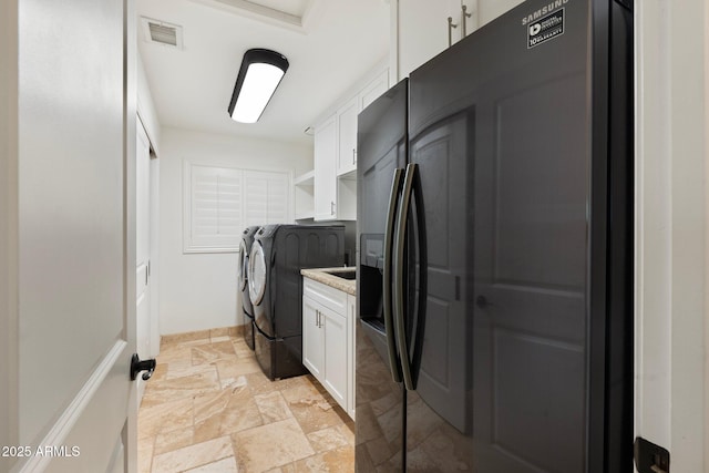 7734 E Monica Dr, Scottsdale, AZ 85255 - laundry room with washer and clothes dryer, cabinet space, stone tile flooring, and baseboards
