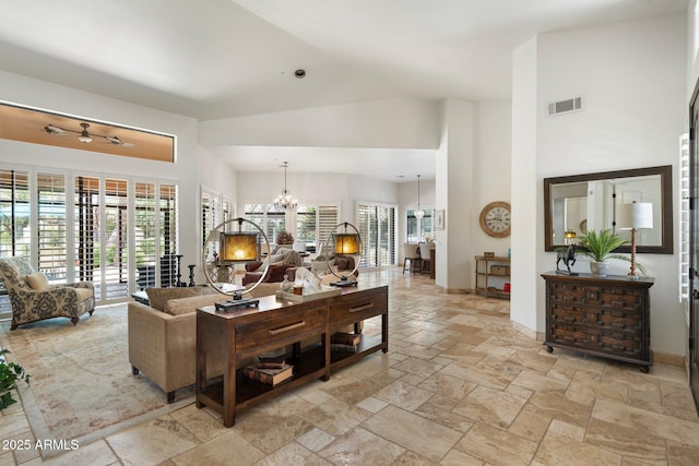 7734 E Monica Dr, Scottsdale, AZ 85255 - living room with high vaulted ceiling, a chandelier, healthy amount of natural light, and stone tile floors