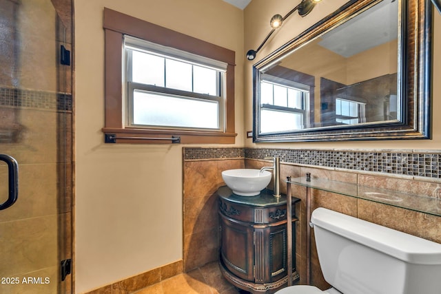 full bath featuring tile walls, a shower stall, toilet, vanity, and tile patterned floors