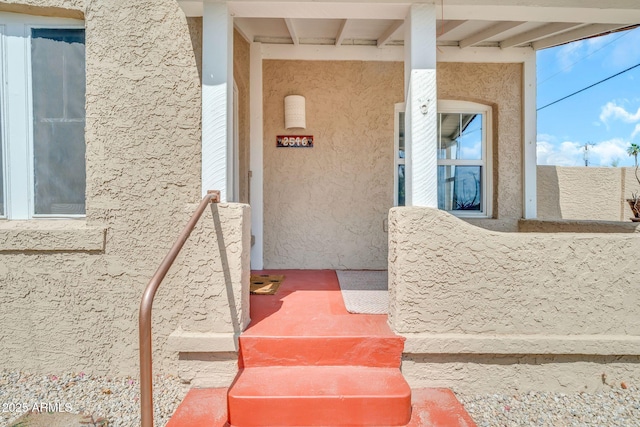 view of exterior entry featuring stucco siding