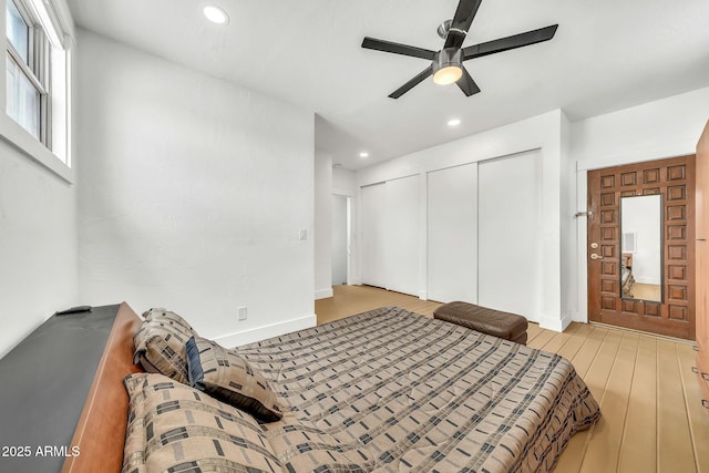 bedroom with multiple closets, wood finished floors, recessed lighting, ceiling fan, and baseboards