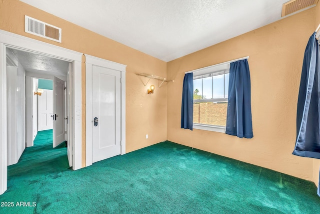 unfurnished bedroom with carpet flooring and a textured ceiling