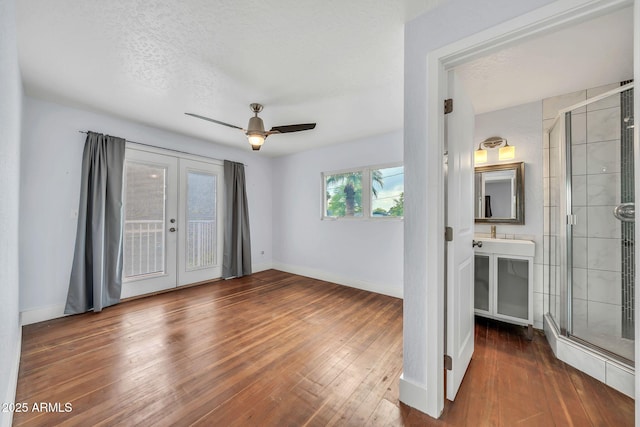 unfurnished bedroom featuring access to exterior, hardwood / wood-style flooring, baseboards, french doors, and ceiling fan