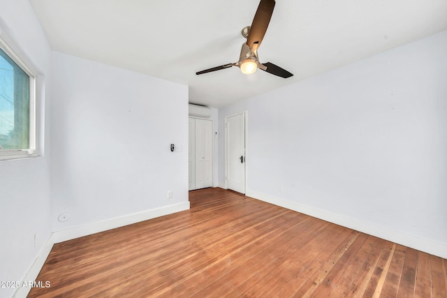 unfurnished room with baseboards, wood-type flooring, and ceiling fan