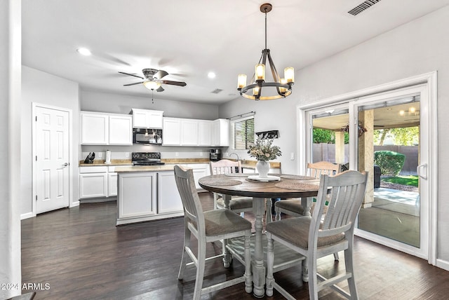 dining room featuring dark hardwood / wood-style flooring, plenty of natural light, and ceiling fan with notable chandelier