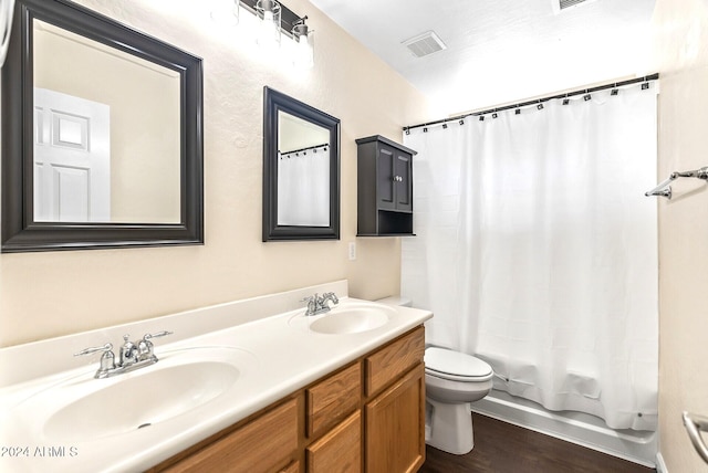 full bathroom featuring hardwood / wood-style flooring, shower / bath combo, toilet, and vanity