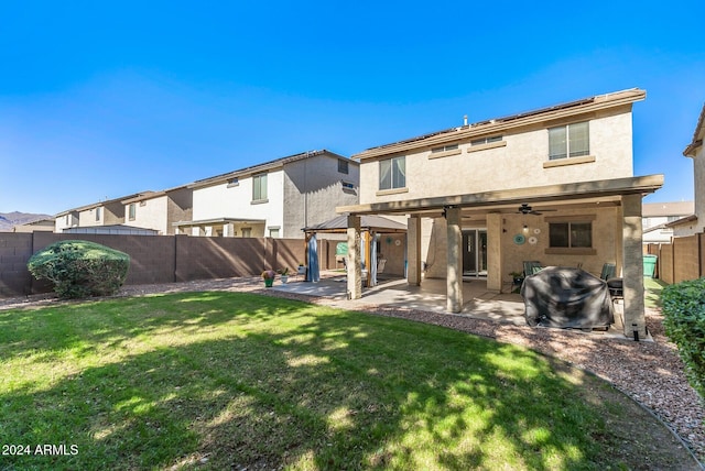 back of property featuring a yard, ceiling fan, and a patio area