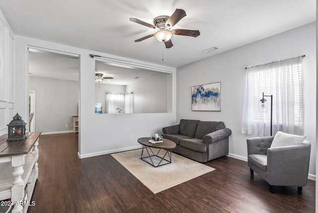 living room featuring ceiling fan and dark wood-type flooring