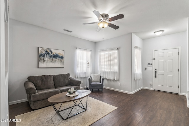 living room with ceiling fan and dark wood-type flooring