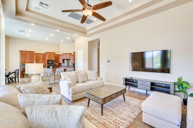 795 W Verbena Ln, Litchfield Park, AZ 85340 - living area with a ceiling fan, a tray ceiling, a towering ceiling, recessed lighting, and light tile patterned floors