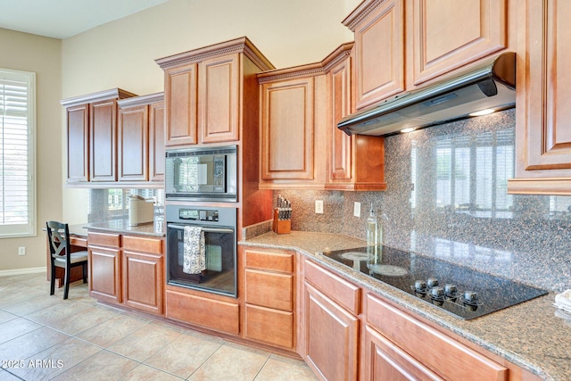 795 W Verbena Ln, Litchfield Park, AZ 85340 - kitchen featuring black appliances, under cabinet range hood, backsplash, baseboards, and light tile patterned flooring