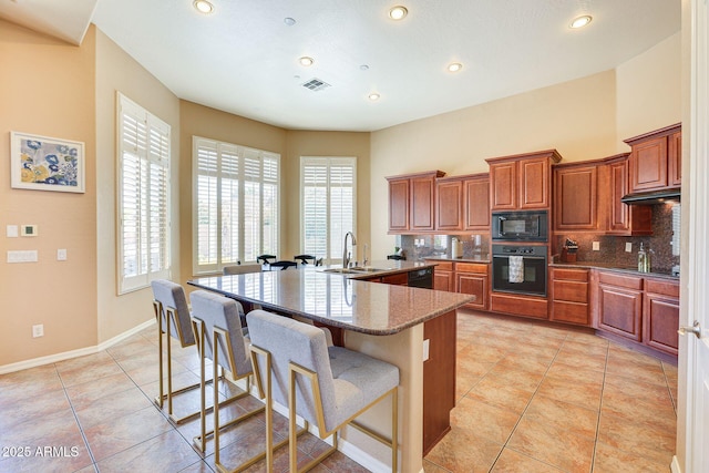 795 W Verbena Ln, Litchfield Park, AZ 85340 - kitchen with black appliances, a sink, a breakfast bar, healthy amount of natural light, and recessed lighting