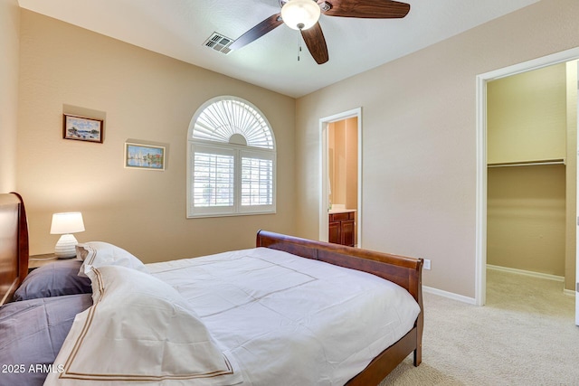 795 W Verbena Ln, Litchfield Park, AZ 85340 - bedroom featuring light colored carpet, baseboards, a spacious closet, a ceiling fan, and ensuite bath