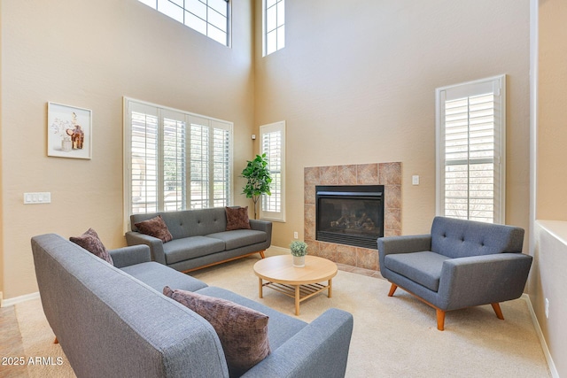 795 W Verbena Ln, Litchfield Park, AZ 85340 - living area featuring a towering ceiling, a tile fireplace, baseboards, and carpet flooring