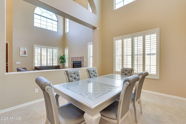 795 W Verbena Ln, Litchfield Park, AZ 85340 - dining area featuring carpet, a tile fireplace, a towering ceiling, and baseboards