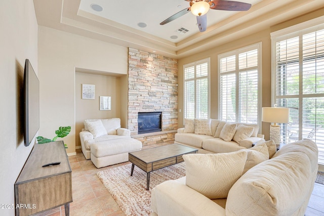 795 W Verbena Ln, Litchfield Park, AZ 85340 - living area with ceiling fan, a tray ceiling, light tile patterned floors, and a fireplace