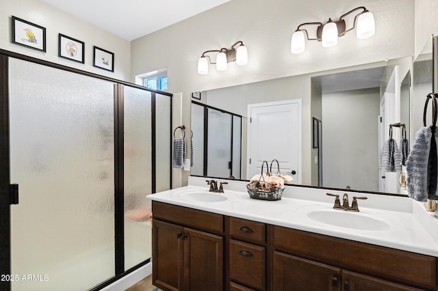 full bathroom featuring double vanity, a sink, and a shower stall