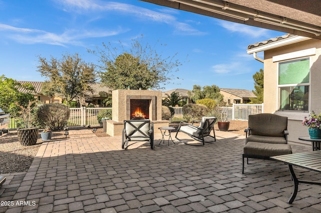 view of patio featuring fence and an outdoor stone fireplace