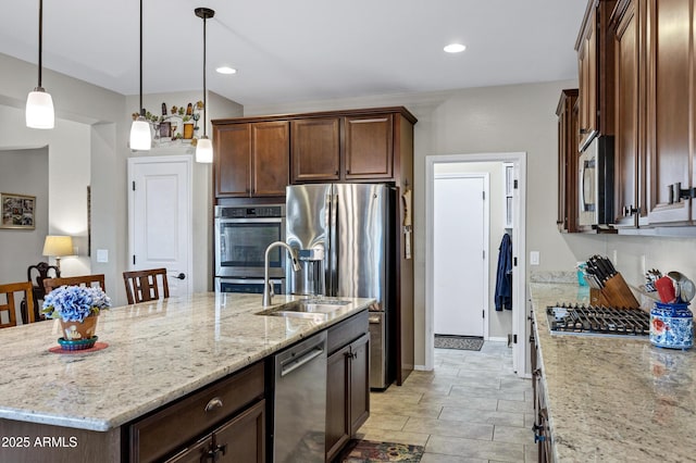 kitchen featuring appliances with stainless steel finishes, light stone counters, decorative light fixtures, a sink, and recessed lighting