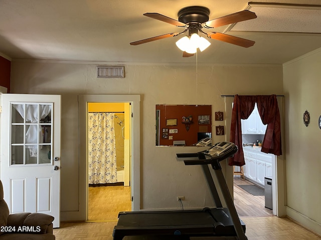 exercise area with ceiling fan, light parquet flooring, and crown molding