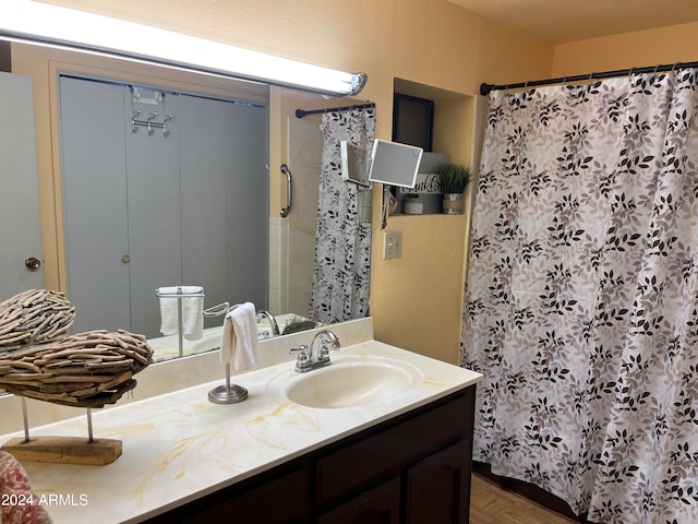 bathroom featuring walk in shower, parquet floors, and vanity