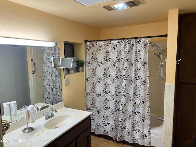 bathroom featuring a textured ceiling, parquet floors, shower / tub combo with curtain, and vanity