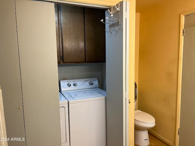 clothes washing area with washing machine and dryer and cabinets