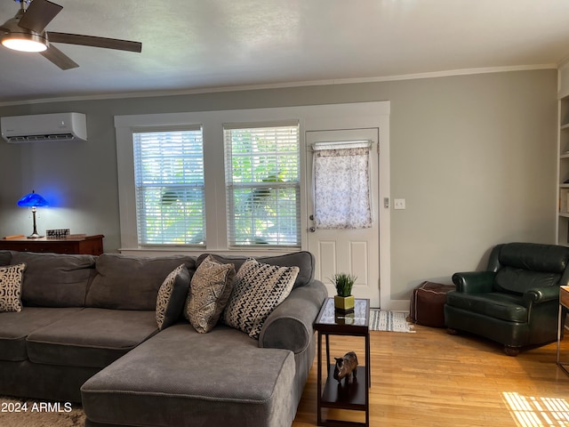 living room with ornamental molding, wood-type flooring, a wall unit AC, and ceiling fan