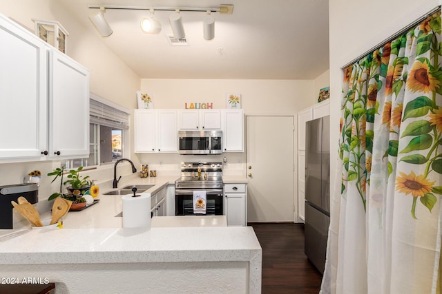 kitchen with sink, white cabinets, appliances with stainless steel finishes, and kitchen peninsula