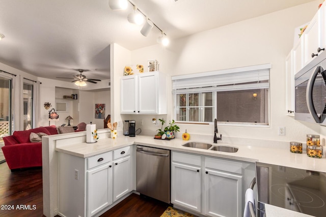 kitchen with white cabinets, kitchen peninsula, appliances with stainless steel finishes, and sink