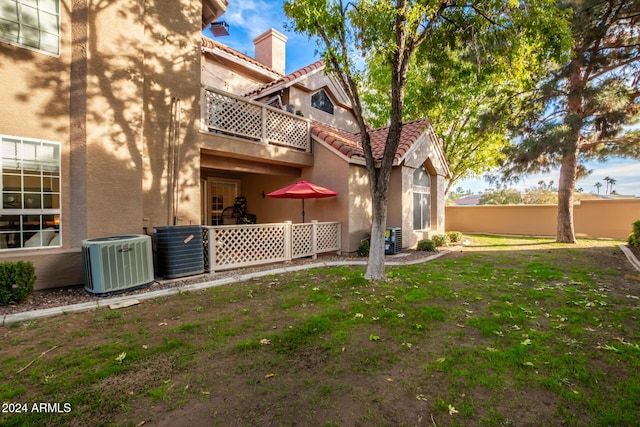 back of property with a yard and central air condition unit