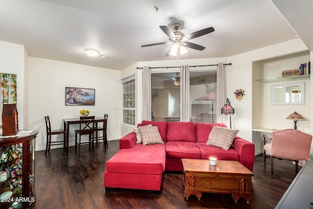 living room with dark wood-type flooring and ceiling fan