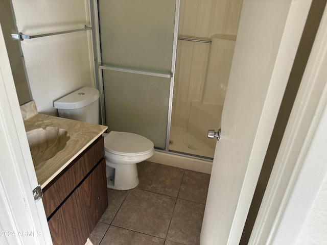 bathroom featuring tile patterned floors, vanity, toilet, and walk in shower