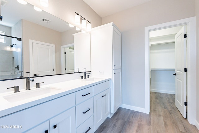 bathroom featuring an enclosed shower, vanity, and wood-type flooring