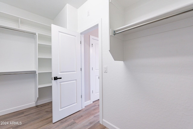 spacious closet with hardwood / wood-style flooring