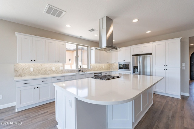 kitchen with island range hood, stainless steel appliances, a center island, sink, and white cabinetry