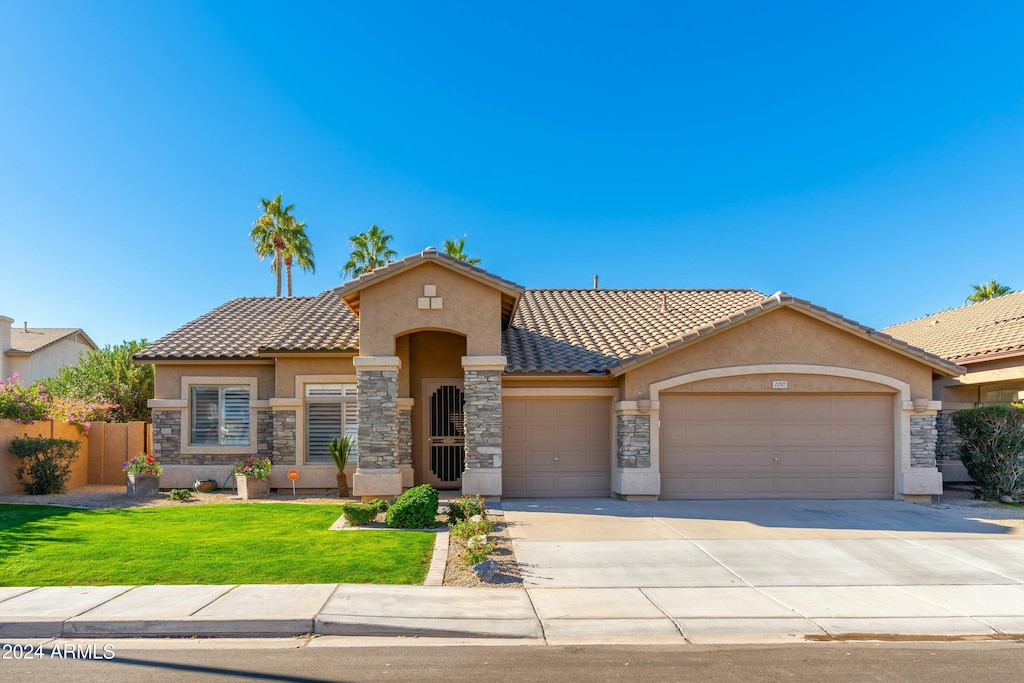 view of front of home with a front lawn and a garage