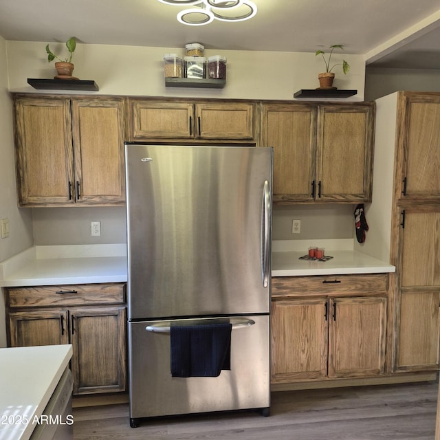 2946 N 14th St N Unit 14, Phoenix, AZ 85014 - kitchen with freestanding refrigerator, wood finished floors, brown cabinetry, and light countertops