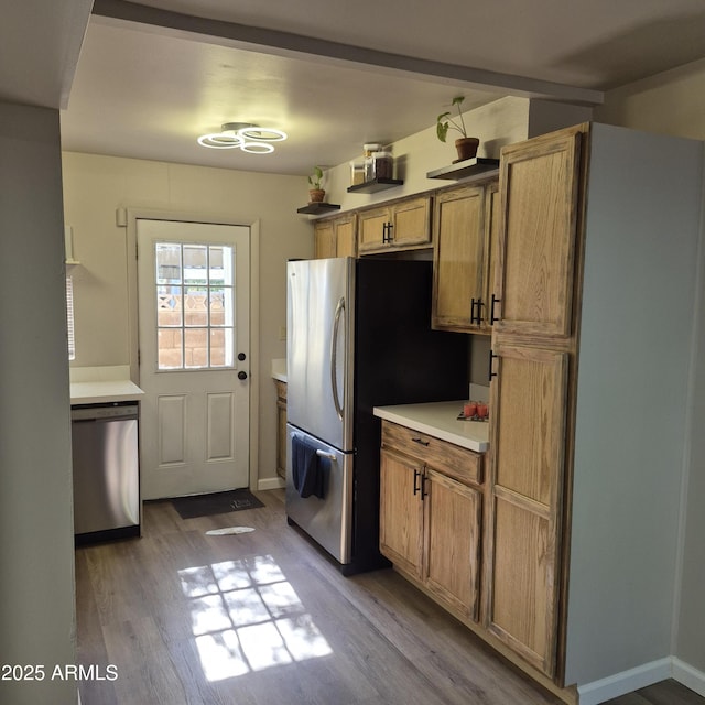 2946 N 14th St N Unit 14, Phoenix, AZ 85014 - kitchen with appliances with stainless steel finishes, wood finished floors, light countertops, and brown cabinets