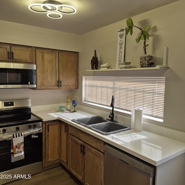 2946 N 14th St N Unit 14, Phoenix, AZ 85014 - kitchen featuring stainless steel appliances, light countertops, brown cabinetry, and dark wood-type flooring