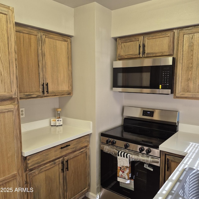2946 N 14th St N Unit 14, Phoenix, AZ 85014 - kitchen featuring stainless steel appliances, brown cabinets, and light countertops