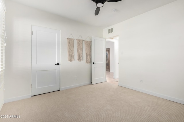 unfurnished bedroom featuring light carpet, visible vents, and baseboards