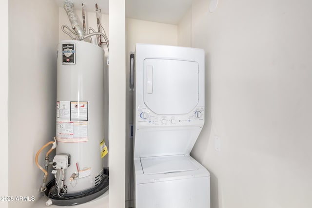 clothes washing area featuring stacked washer and dryer, laundry area, and water heater